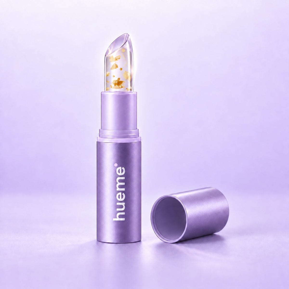 hueme Adaptive Lip with the cap off: clear balm with gold flakes